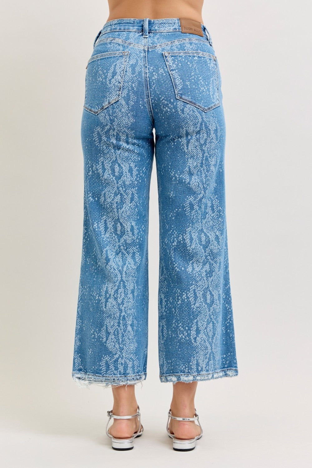 Blue acid-wash jeans worn by a person on a white background