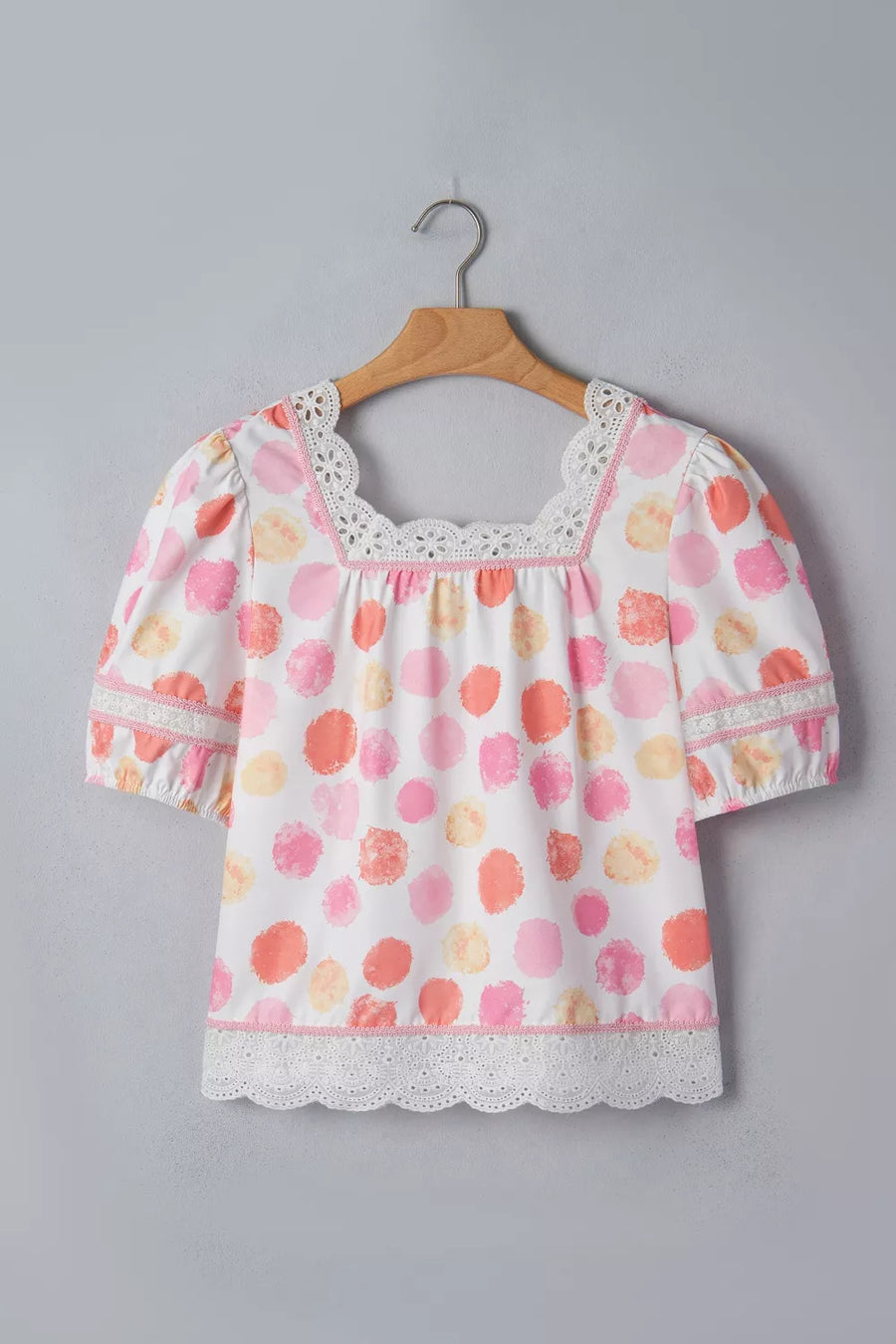 Floral blouse on a hanger against a gray background