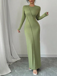 Green evening gown worn by a model against a plain background