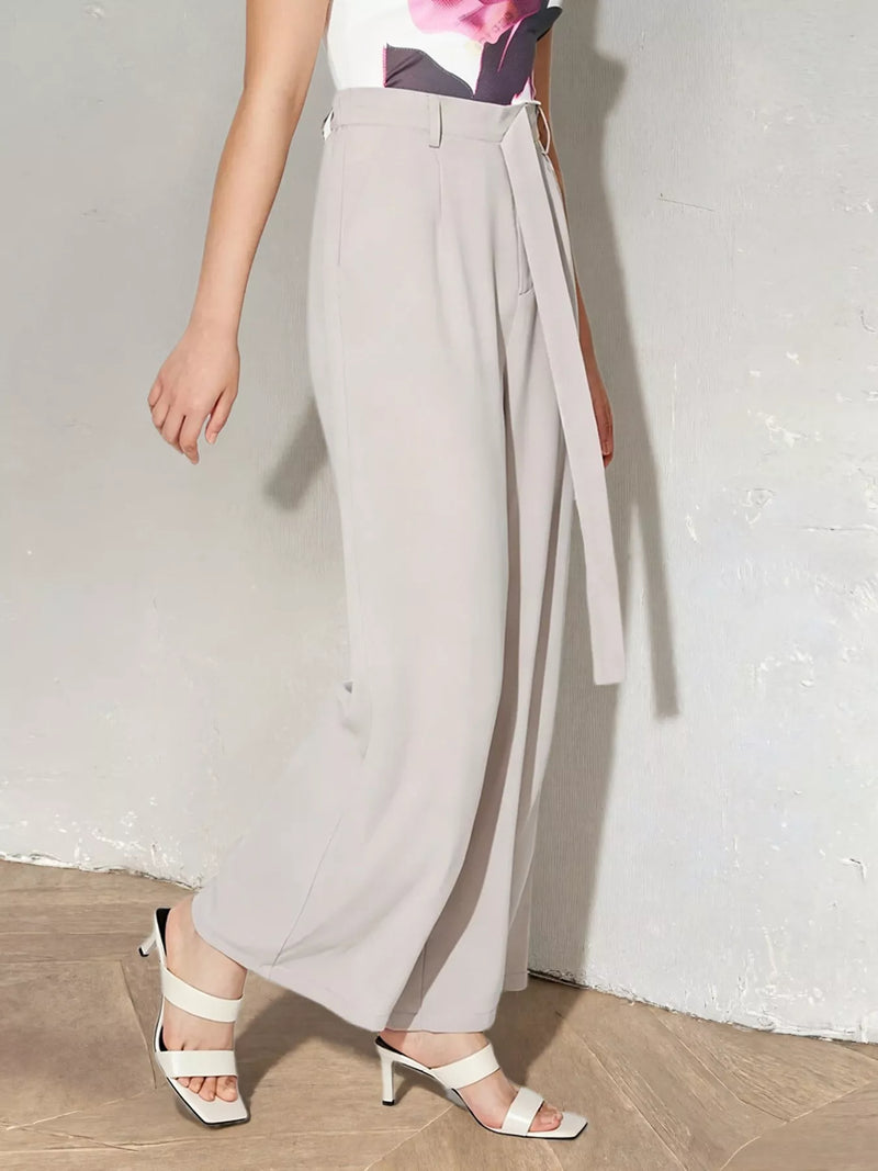 Person wearing light gray wide-leg pants with a white background