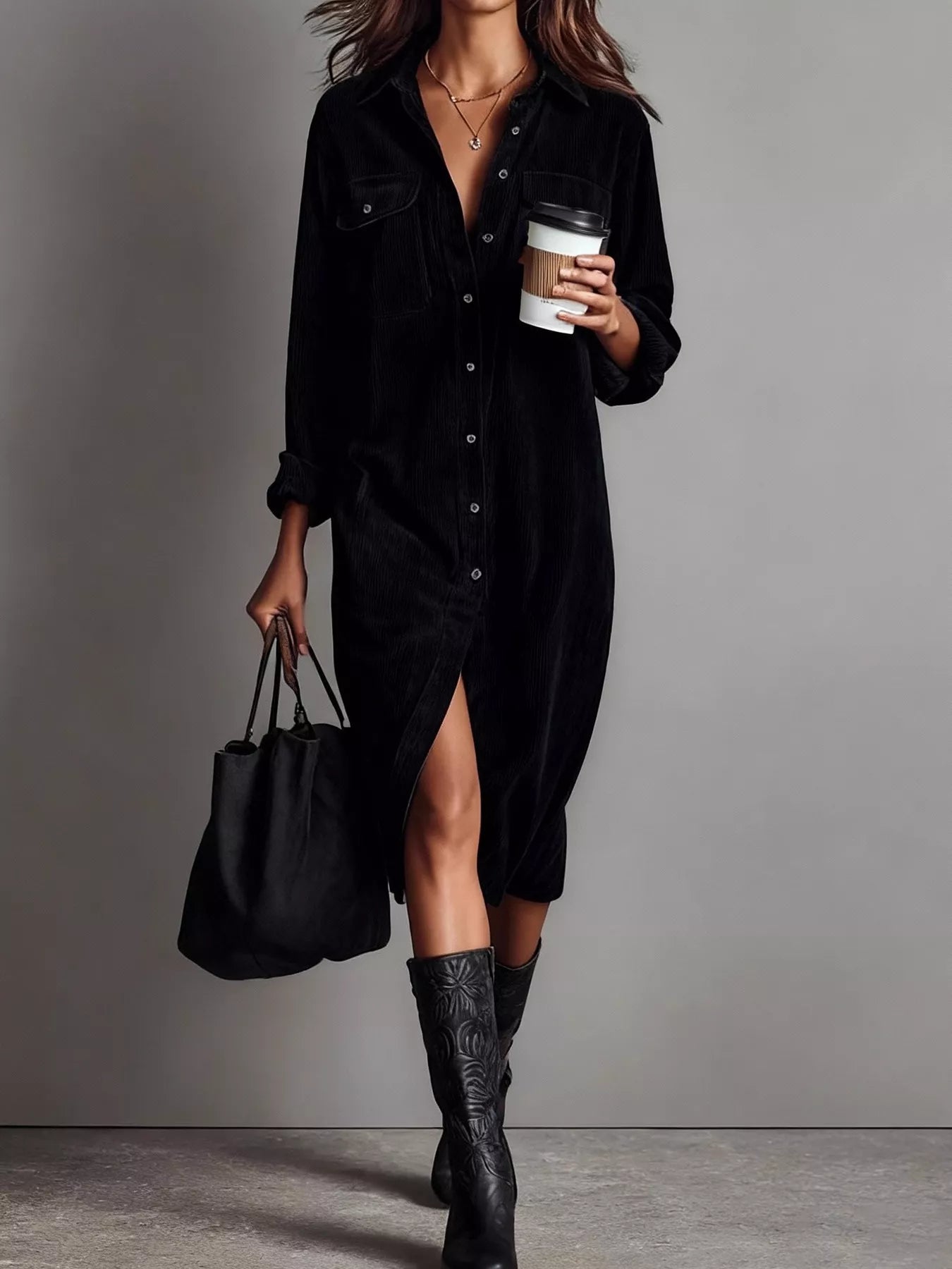 Person wearing a black dress and boots, holding a coffee cup and black bag on a gray background