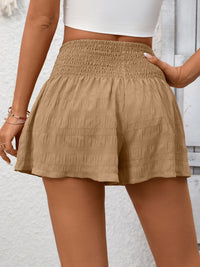 Beige shorts worn by a person against a light background