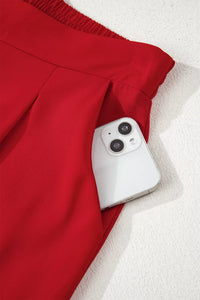 White smartphone with dual camera setup on a red fabric background