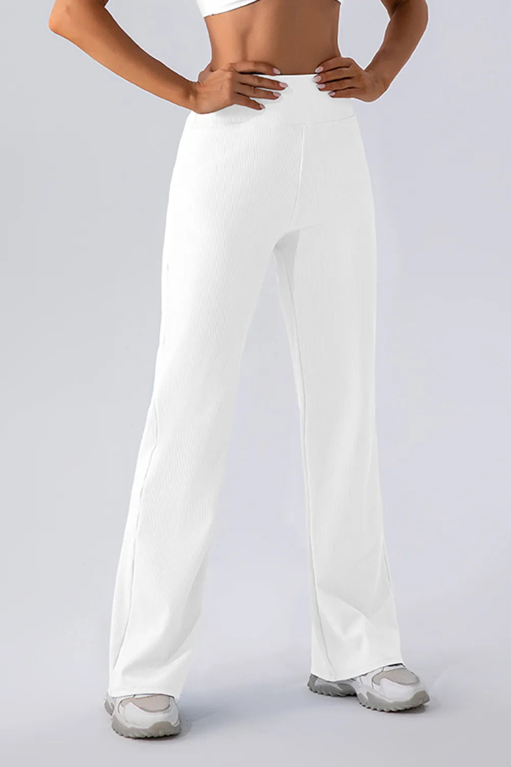 Person wearing white wide-leg pants on a plain background