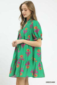 Woman wearing a green dress with floral patterns on a white background