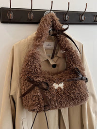 Brown fur coat with a matching fur bag hanging on a rack.