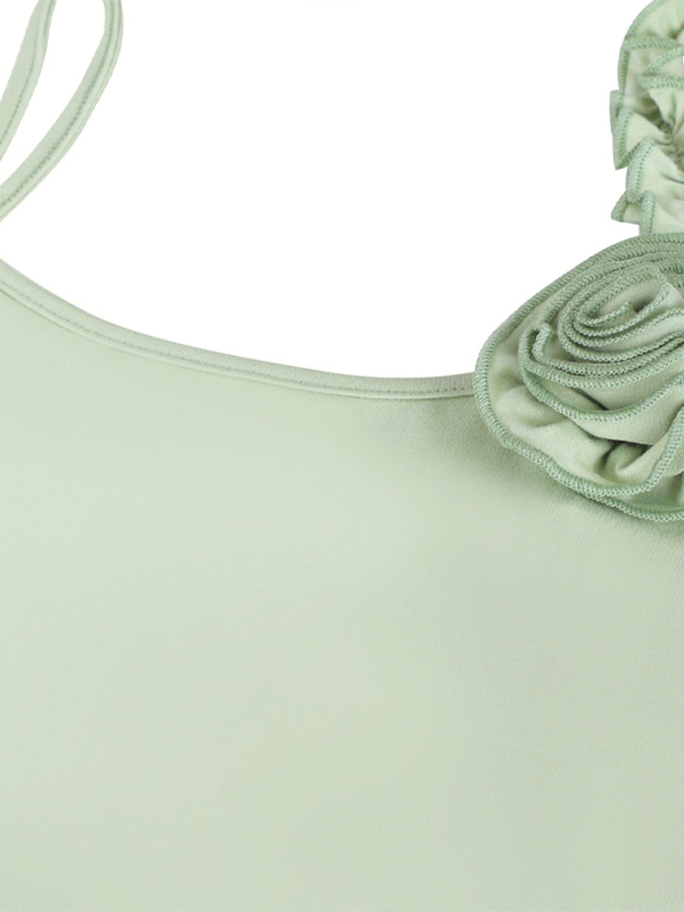 Light green top with a floral detail on a white background