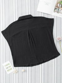 Black sleeveless top on a white background with decorative elements.