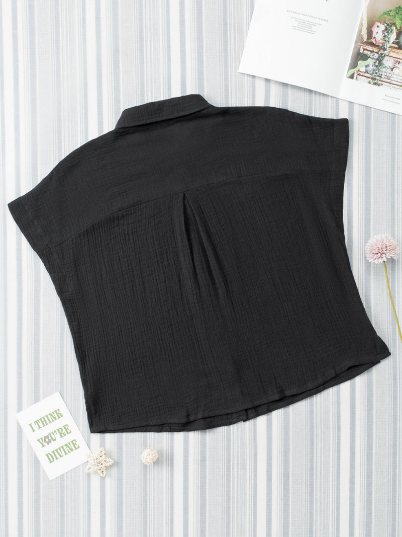 Black sleeveless top on a white background with decorative elements.