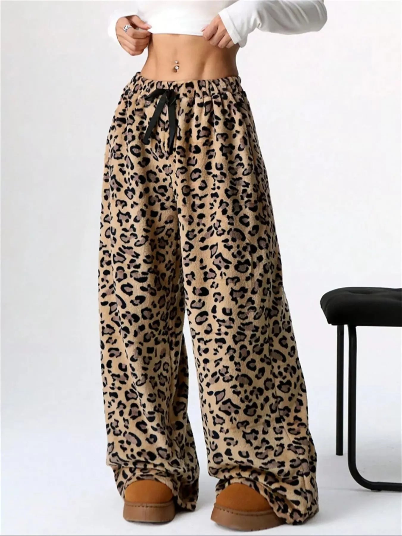 Leopard print pants worn by a person on a white background