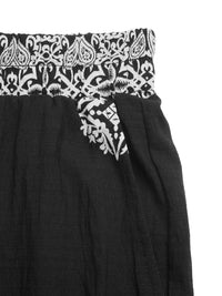 Black skirt with white paisley patterned waistband on a white background