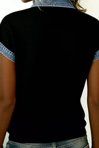 Black top with denim trim on a plain background