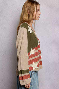 Woman wearing a sweater with American flag design against a plain background