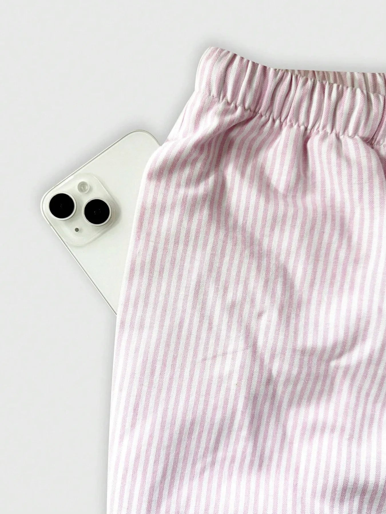 Pink striped pants on a white background with a smartphone.