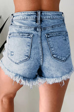 Light blue denim shorts with frayed hem on a neutral background