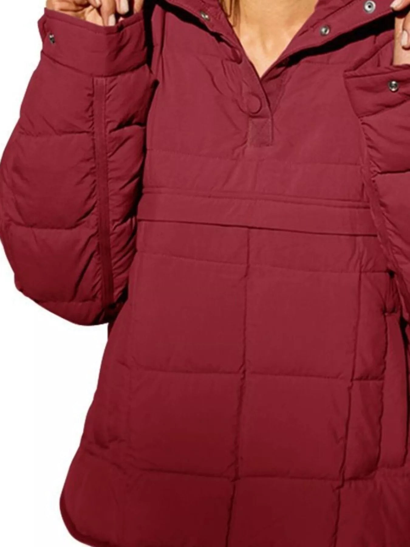 Close-up of a red puffer jacket with a hood on a white background