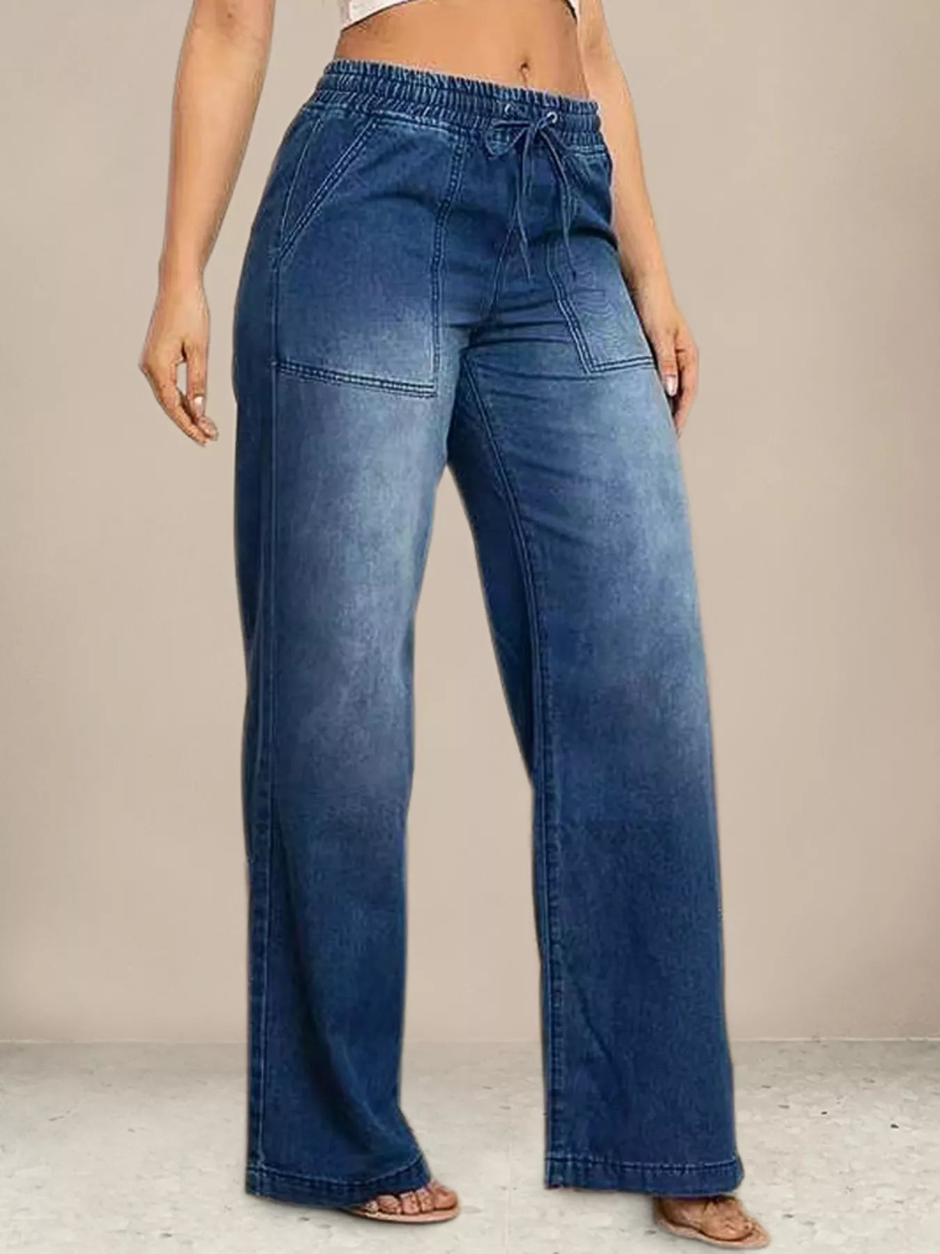 Blue jeans worn by a person on a neutral background