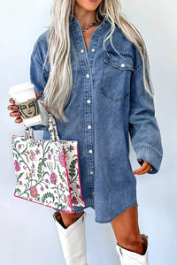 Person wearing a denim shirt dress holding a floral tote bag and a coffee cup.