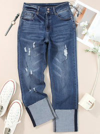 Distressed blue jeans with patchwork design on a light background