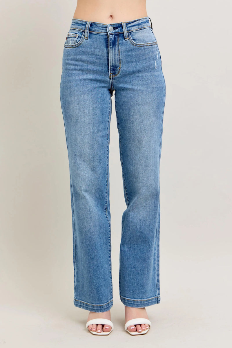 Blue jeans worn by a person on a plain background