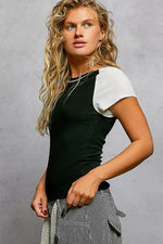 Woman wearing a black and white top with a gray background