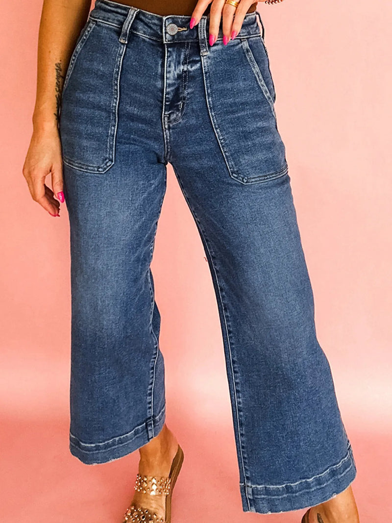 Wide-leg jeans worn by a person on a pink background