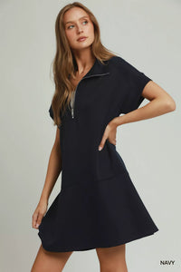 Woman wearing a navy dress on a plain background