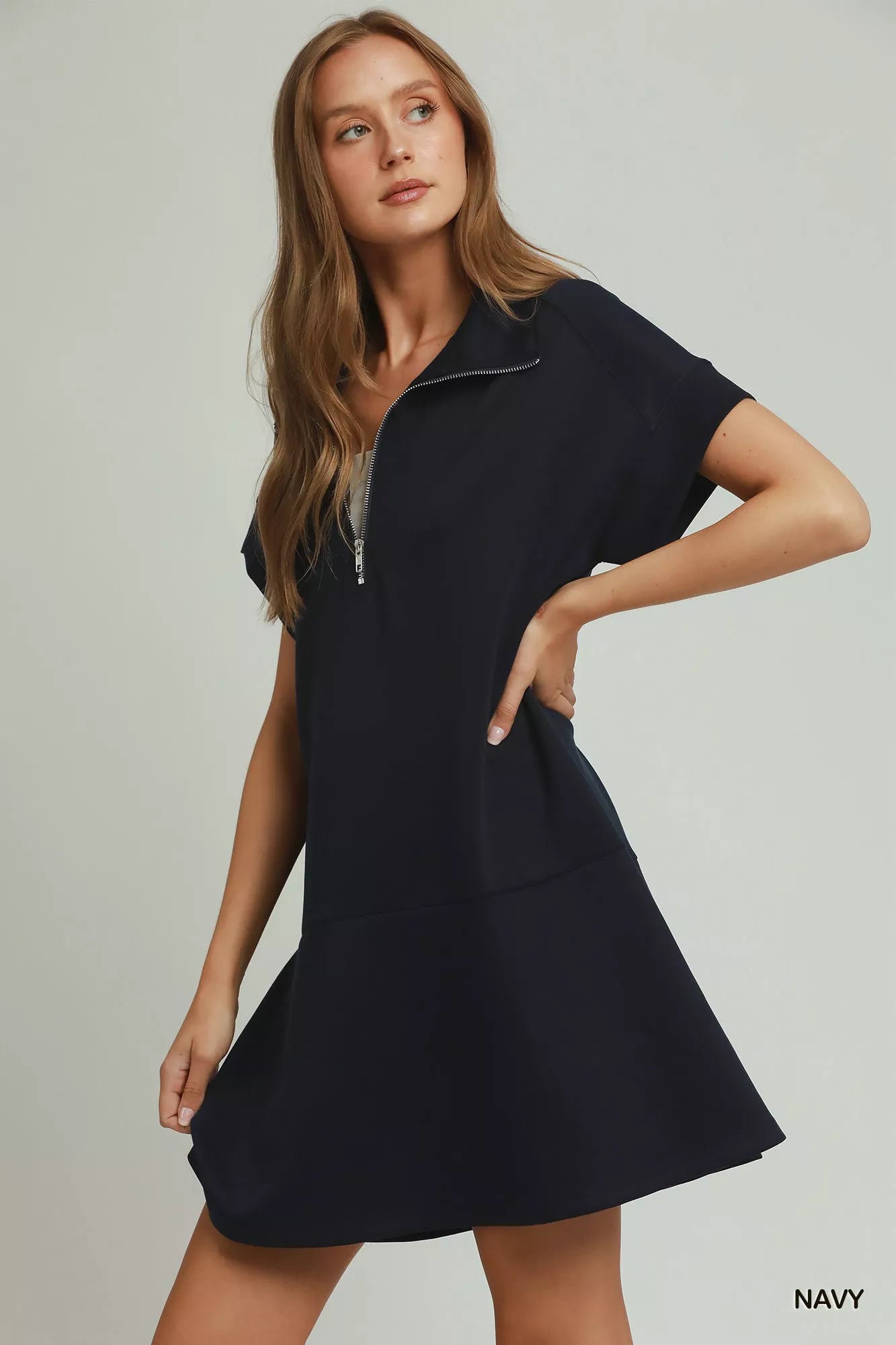Woman wearing a navy dress on a plain background