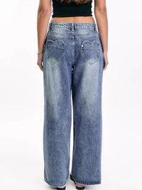 Light blue jeans with heart-shaped pockets worn by a person on a white background