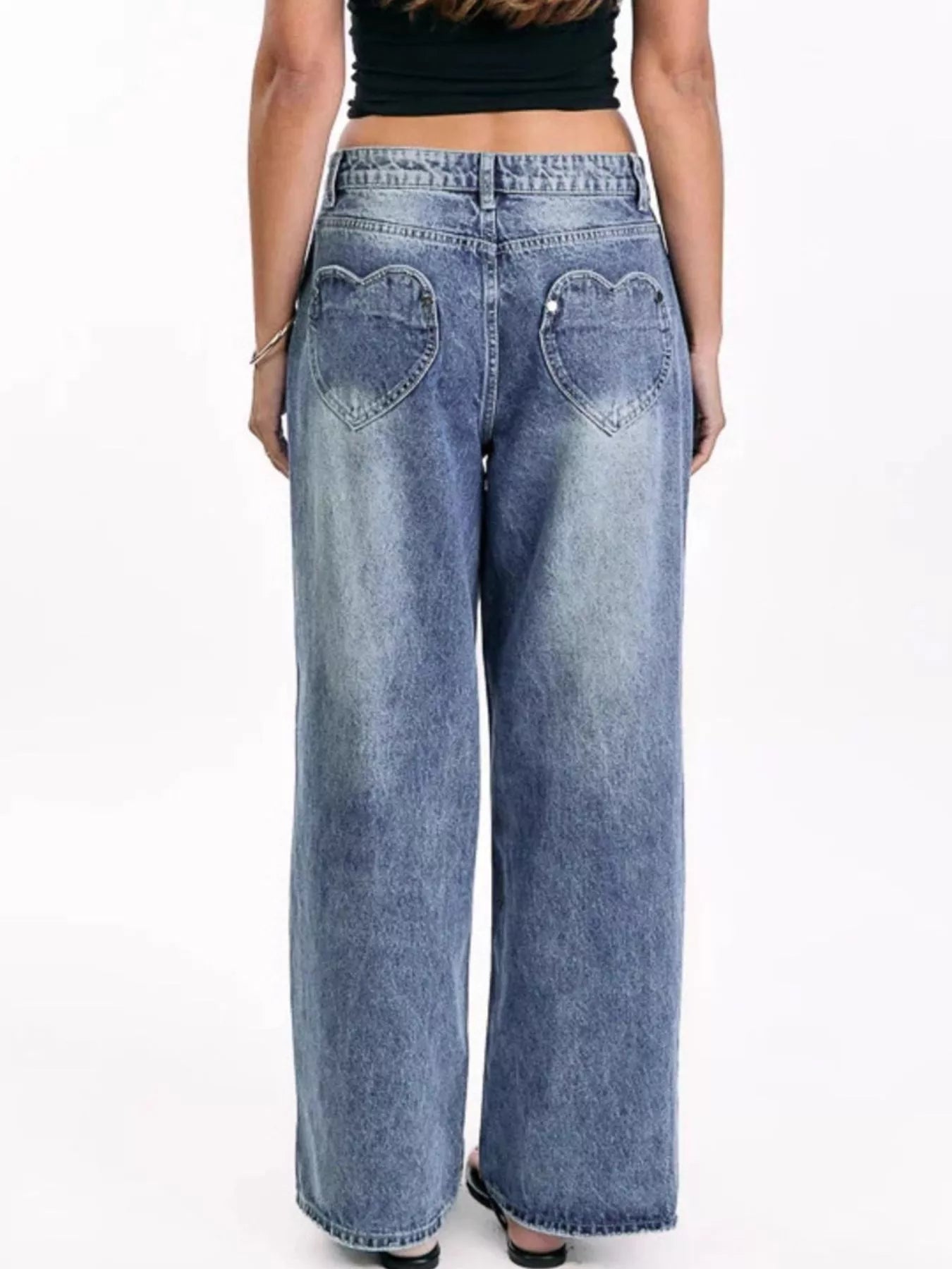 Light blue jeans with heart-shaped pockets worn by a person on a white background