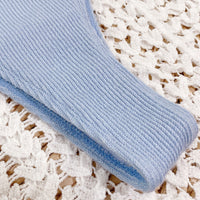 Light blue textured fabric roll on a textured white surface