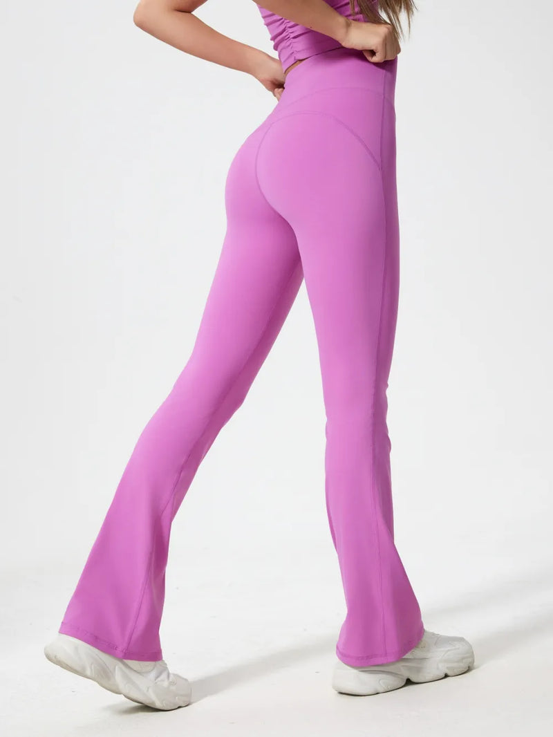 Person wearing pink flared pants on a white background