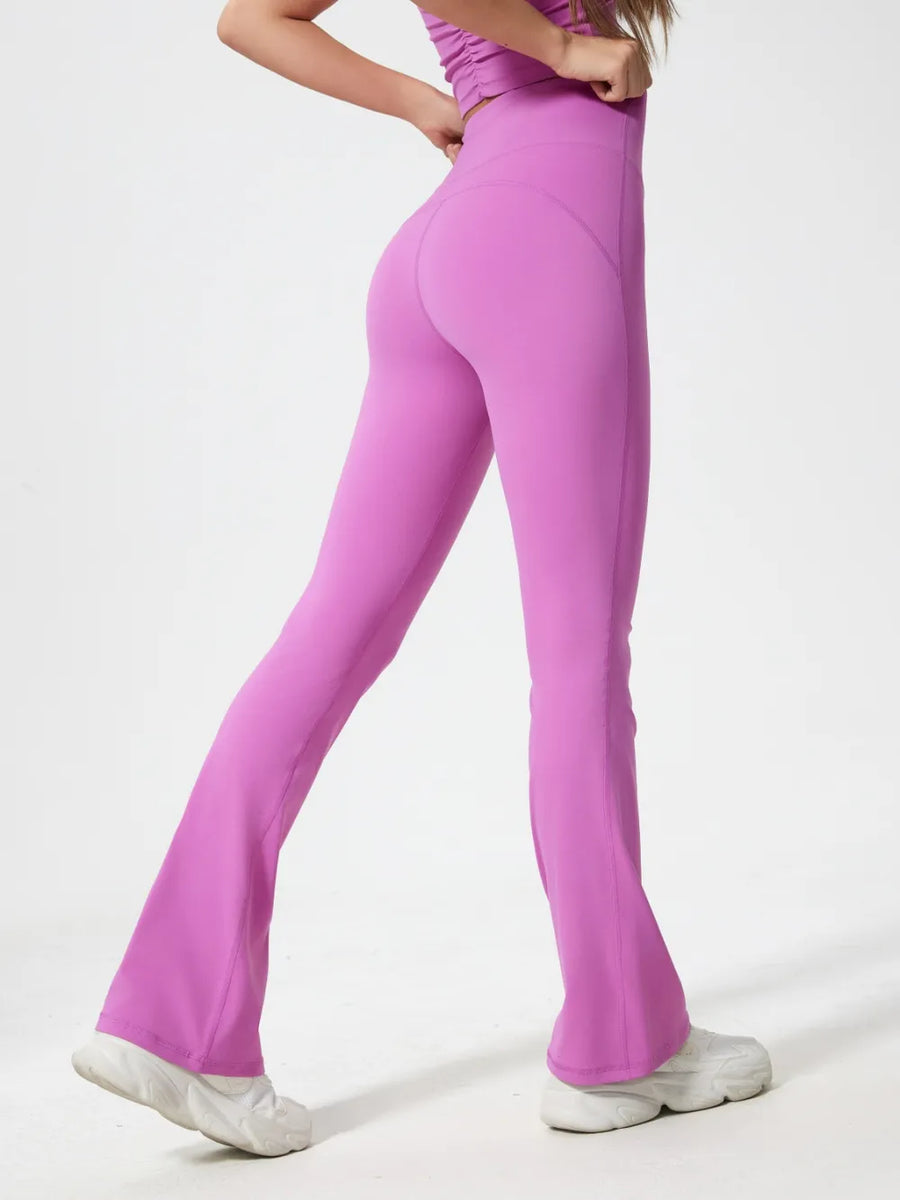 Person wearing pink flared pants on a white background