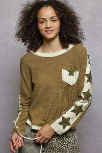 Woman wearing a brown long-sleeve shirt with star patterns on a gray background