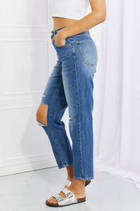 Person wearing blue jeans with cut-out design on a white background
