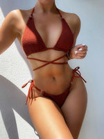 Person wearing a red bikini against a white wall