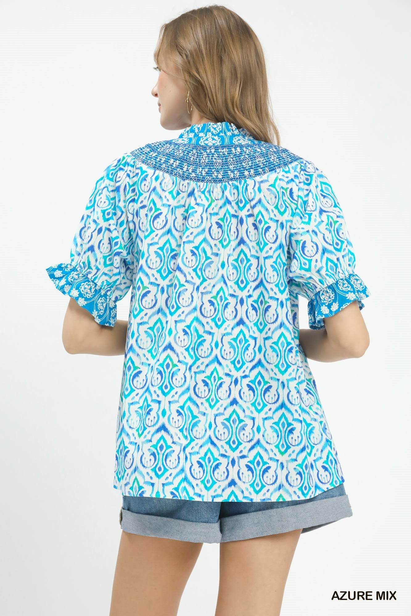 Woman wearing a blue and white patterned shirt on a white background