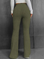 Green ribbed pants worn by a person against a gray background