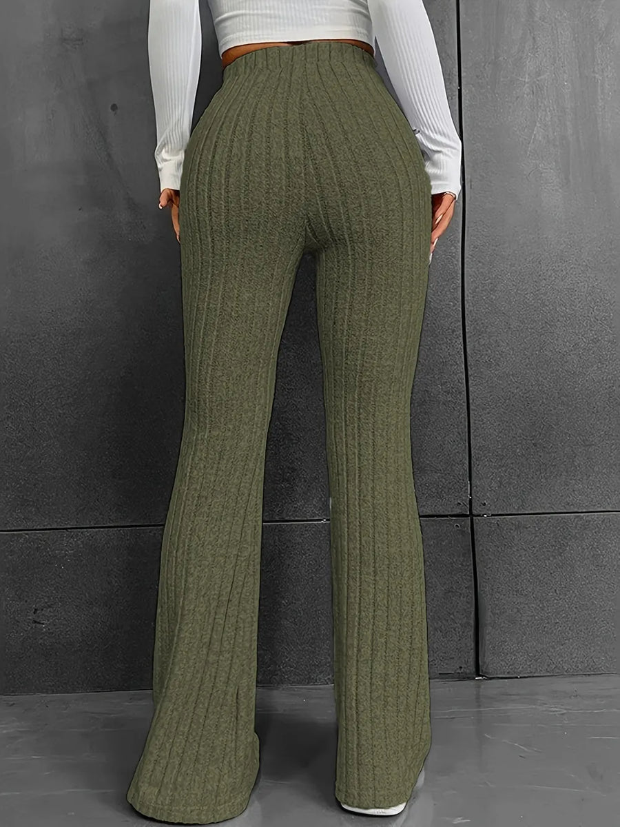 Green ribbed pants worn by a person against a gray background