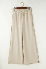 Beige wide-leg pants on a hanger against a white background