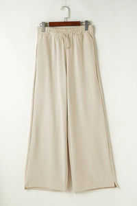 Beige wide-leg pants on a hanger against a white background