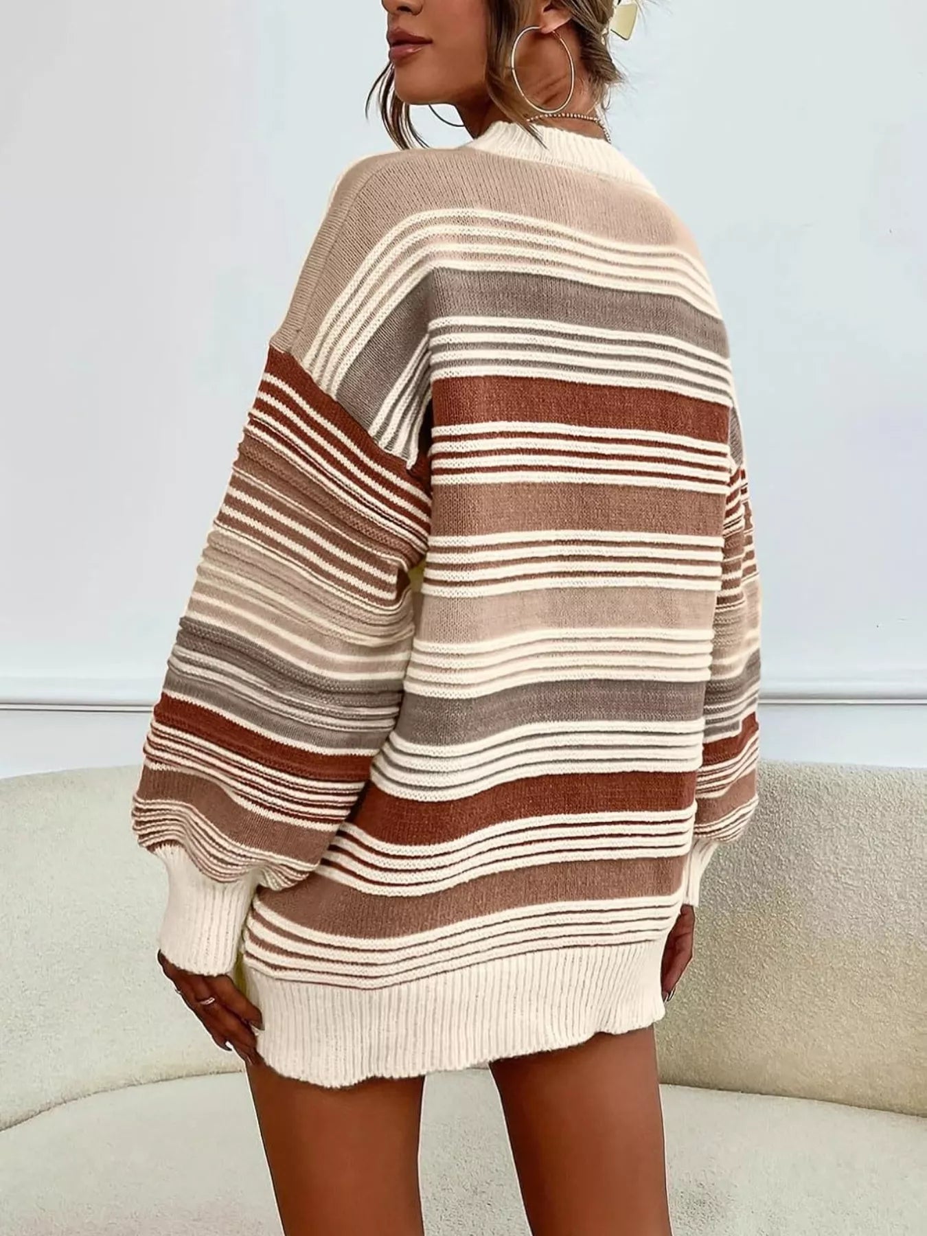 Person wearing a striped sweater with a neutral background