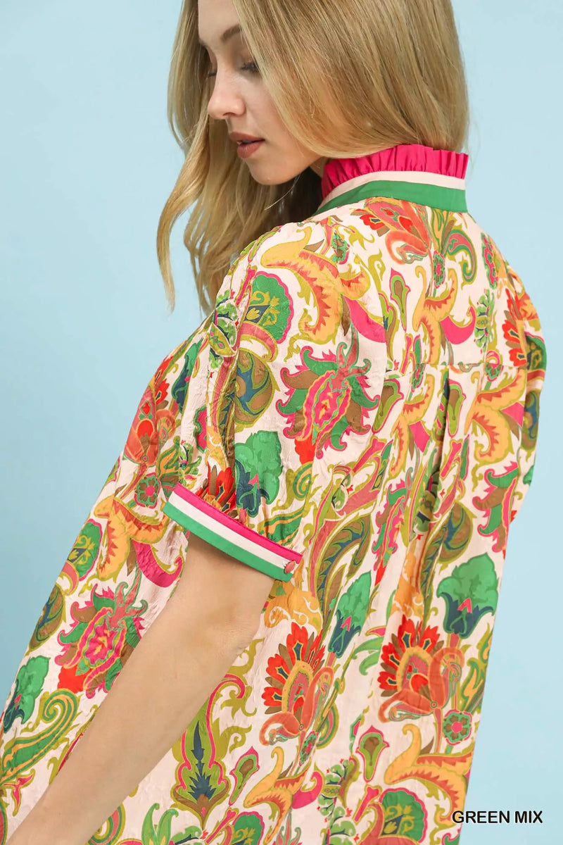 Woman wearing a colorful patterned shirt with a blue background
