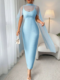 Woman wearing a light blue dress with a sheer overlay in a room.