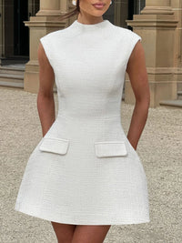 White dress with pockets worn by a model outdoors.