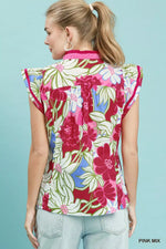 Woman wearing a colorful floral blouse against a light blue background