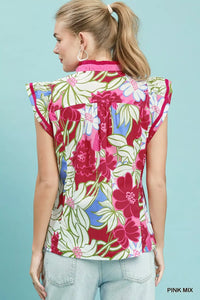 Woman wearing a colorful floral blouse against a light blue background