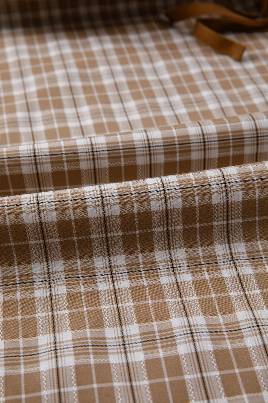 Brown and white checkered fabric with a visible pattern