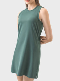Woman wearing a green sleeveless dress on a white background