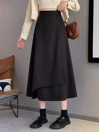 Person wearing a black skirt with a neutral background
